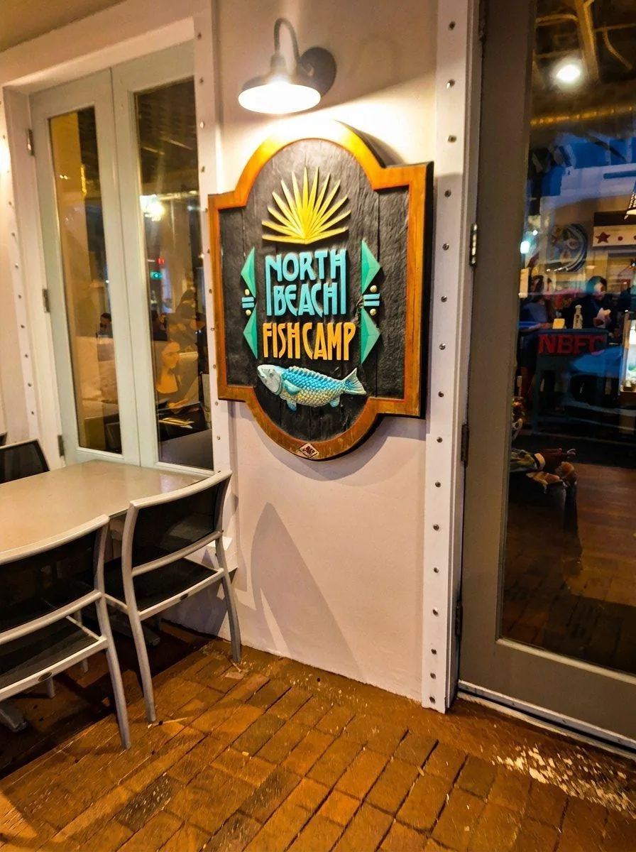 North Beach Fish Camp carved wooden sign with fish sculpture at the entrance, Neptune Beach Florida