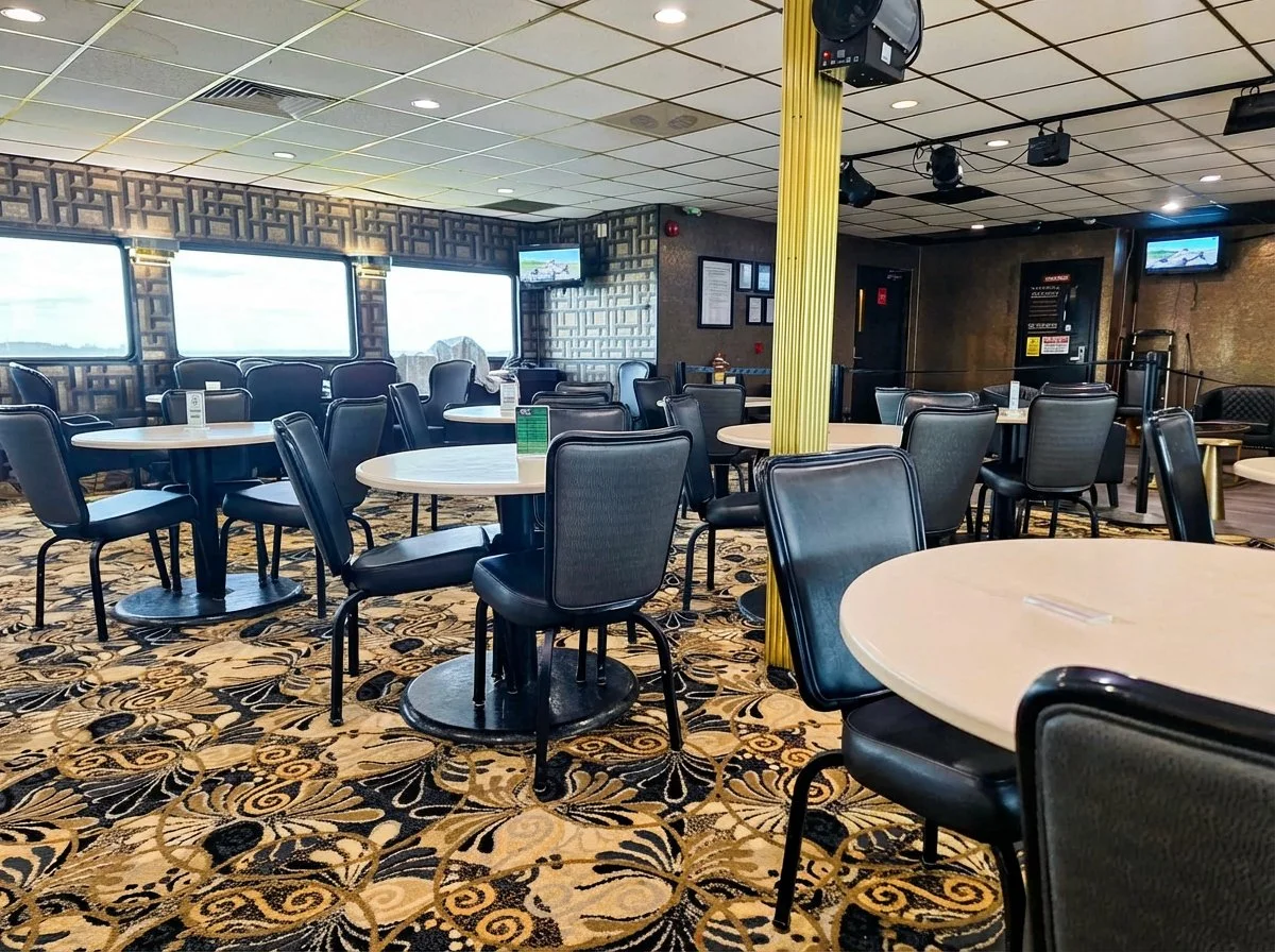 Emerald Princess II dining room with round tables and water views through windows