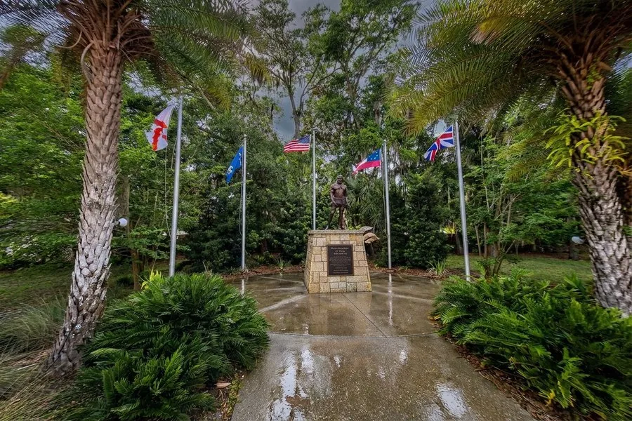 Ponce de Leon statue at the Fountain of Youth Archaeological Park, surrounded by flags of nations that claimed Florida